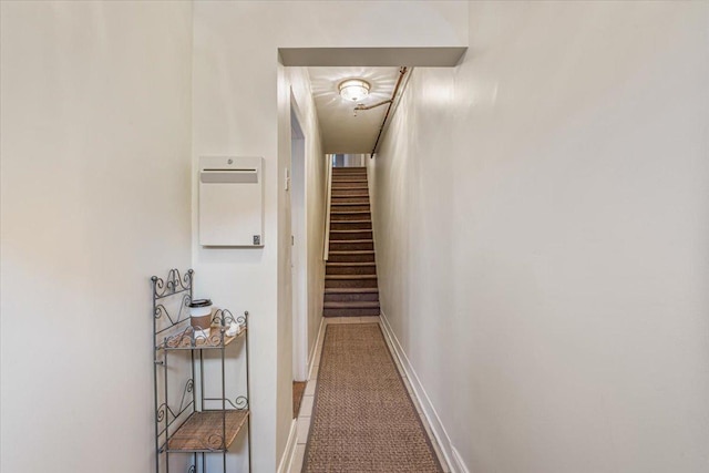 hallway with baseboards and stairway