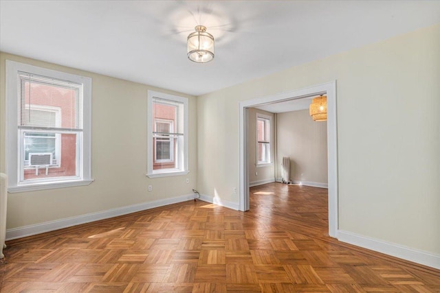 spare room featuring baseboards and radiator