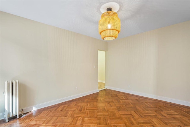 unfurnished room featuring baseboards and radiator heating unit