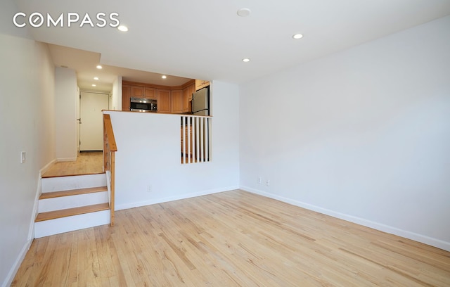 211 Thompson St Unit 5L, New York City, NY 10012 - unfurnished living room with light wood-style flooring, recessed lighting, and stairs