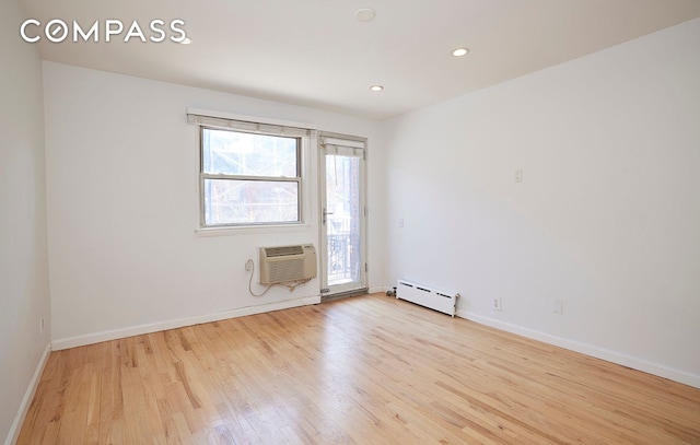 211 Thompson St Unit 5L, New York City, NY 10012 - spare room featuring a wall mounted AC, a baseboard radiator, wood finished floors, baseboards, and recessed lighting
