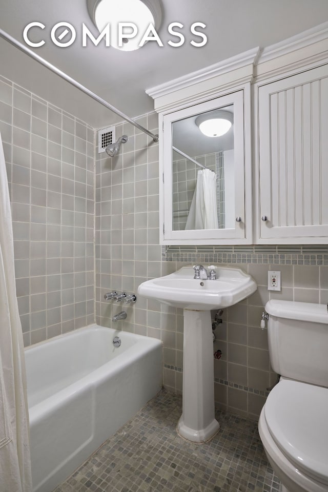 211 Thompson St Unit 5L, New York City, NY 10012 - bathroom featuring shower / bath combination with curtain, tile walls, tile patterned floors, and decorative backsplash