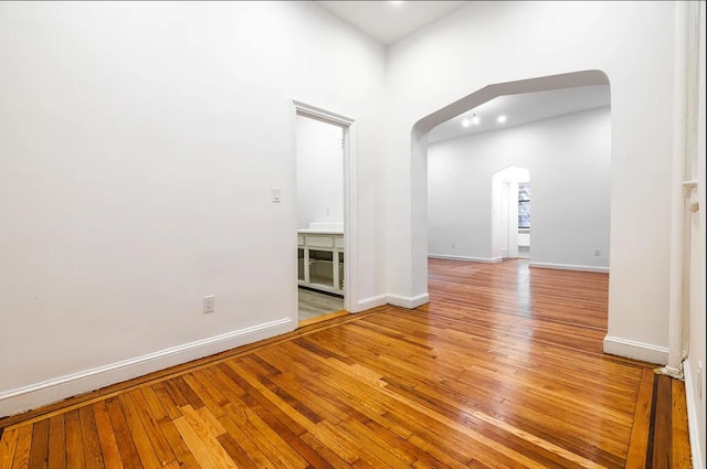 250 W 22nd St Unit 1-B, New York City, NY 10011 - spare room featuring arched walkways, light wood-type flooring, and baseboards