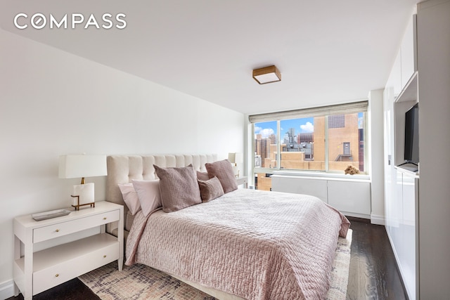 bedroom with baseboards and wood finished floors