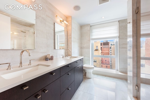bathroom with a sink, a healthy amount of sunlight, and toilet