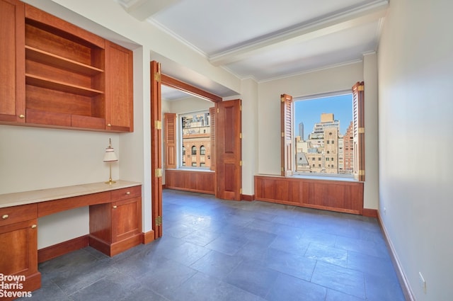 interior space with baseboards, ornamental molding, and stone tile flooring