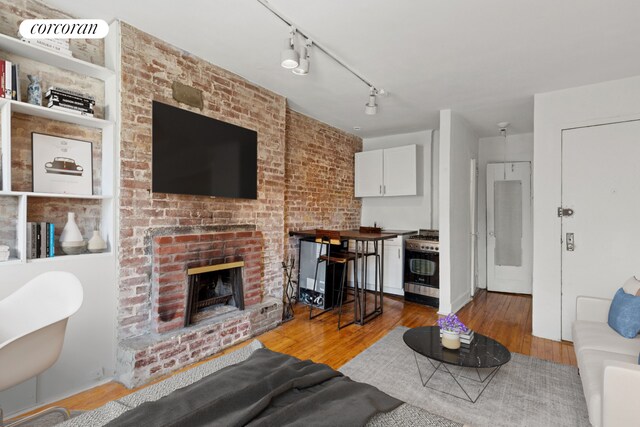 84 Horatio St Unit 4C, New York City, NY 10014 - living room with wood finished floors and a brick fireplace