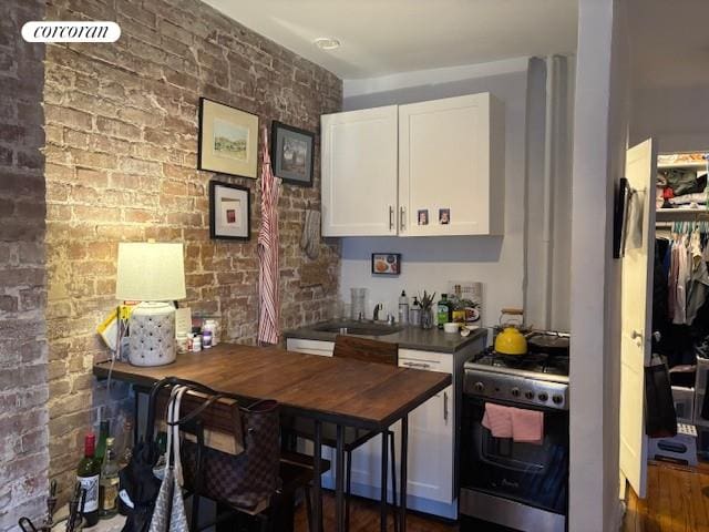 bar with brick wall, gas range oven, and a sink