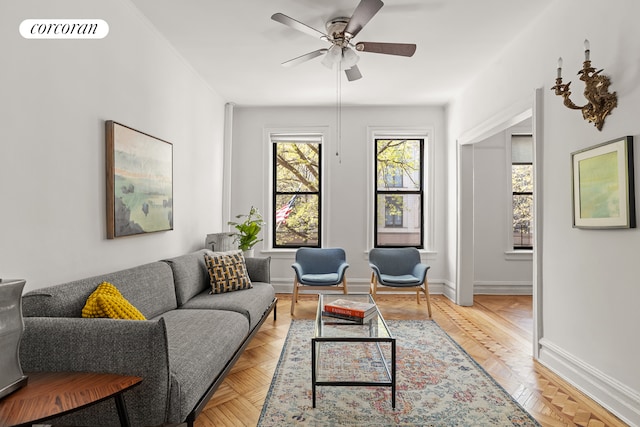 living room with baseboards, a ceiling fan, and visible vents