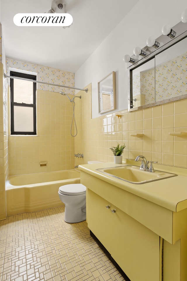 511 8th Ave, New York City, NY 11215 - bathroom with vanity, tub / shower combination, toilet, tile walls, and a wainscoted wall