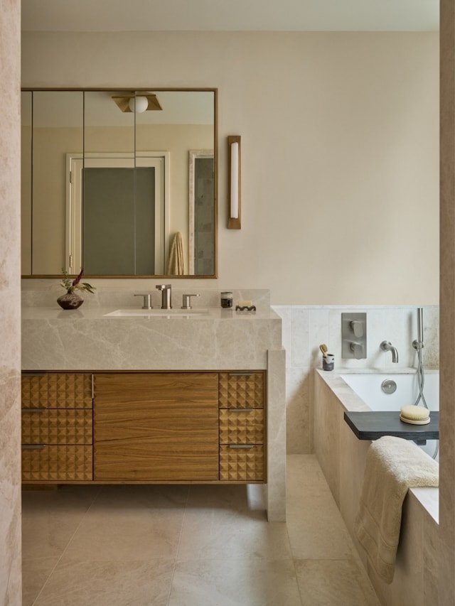 full bath with tile patterned flooring, a bath, and vanity