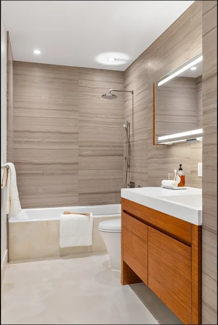 bathroom featuring tile walls, vanity, toilet,  shower combination, and recessed lighting