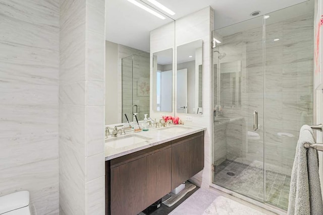 bathroom featuring double vanity, a sink, and toilet