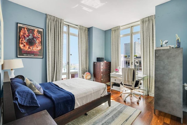 bedroom with access to outside, french doors, and wood finished floors