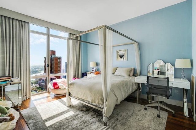 bedroom featuring a view of city and wood finished floors