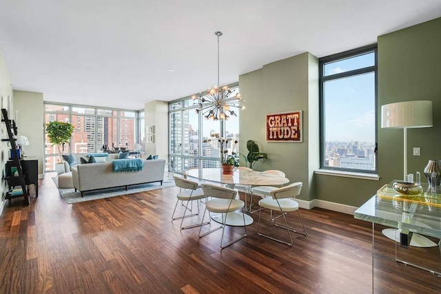 dining area featuring baseboards, wood finished floors, a notable chandelier, and a wall of windows
