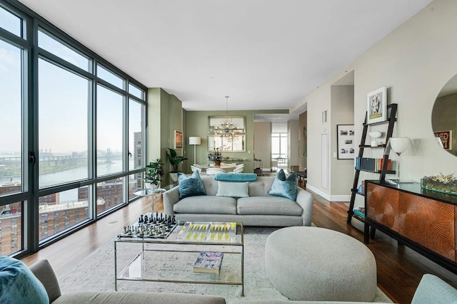 living area featuring an inviting chandelier, baseboards, wood finished floors, and expansive windows