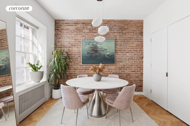dining space featuring radiator and brick wall