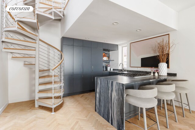 137 E 15th St Unit 2A, New York City, NY 10003 - kitchen featuring dark countertops, a breakfast bar, a sink, recessed lighting, and baseboards