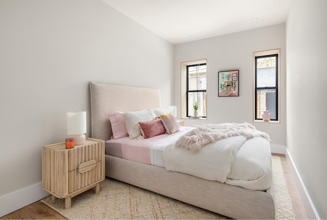 bedroom featuring baseboards and light wood finished floors
