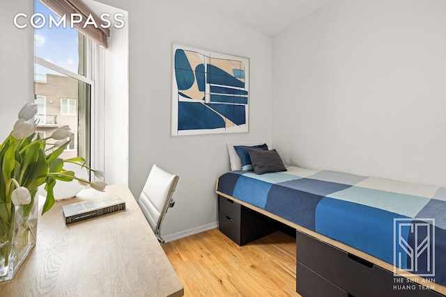 bedroom with baseboards and light wood-type flooring