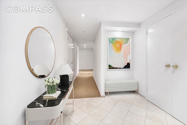 hallway featuring carpet floors, recessed lighting, and tile patterned flooring