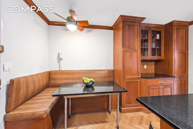 interior space with crown molding, ceiling fan, and breakfast area