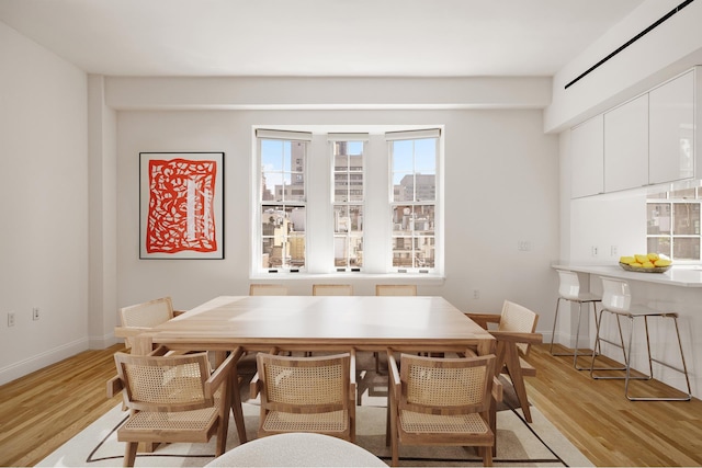 dining room with light wood-type flooring and baseboards