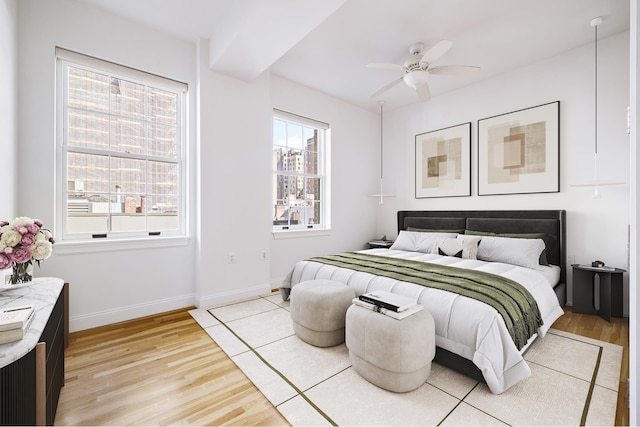 bedroom with light wood-style floors, baseboards, and ceiling fan