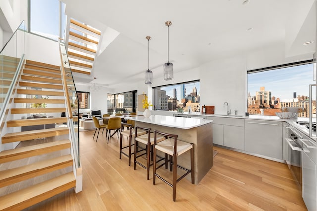 123 3rd Ave Unit Ph18, New York City, NY 10003 - kitchen featuring modern cabinets, a view of skyline, a kitchen island, light wood-type flooring, and recessed lighting