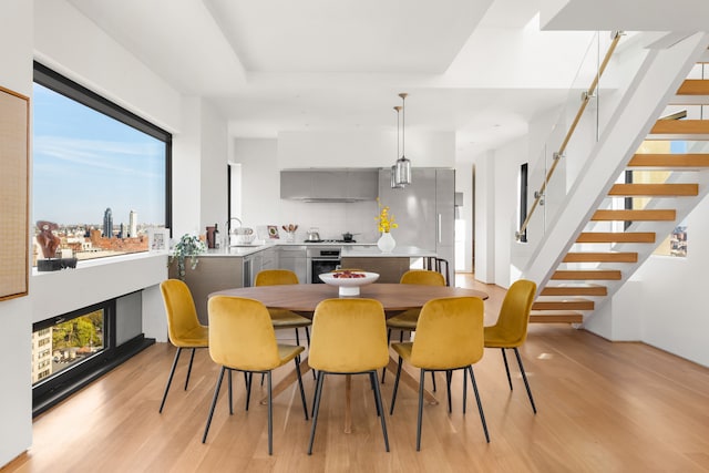 123 3rd Ave Unit Ph18, New York City, NY 10003 - dining space with light wood-type flooring, stairway, and a fireplace