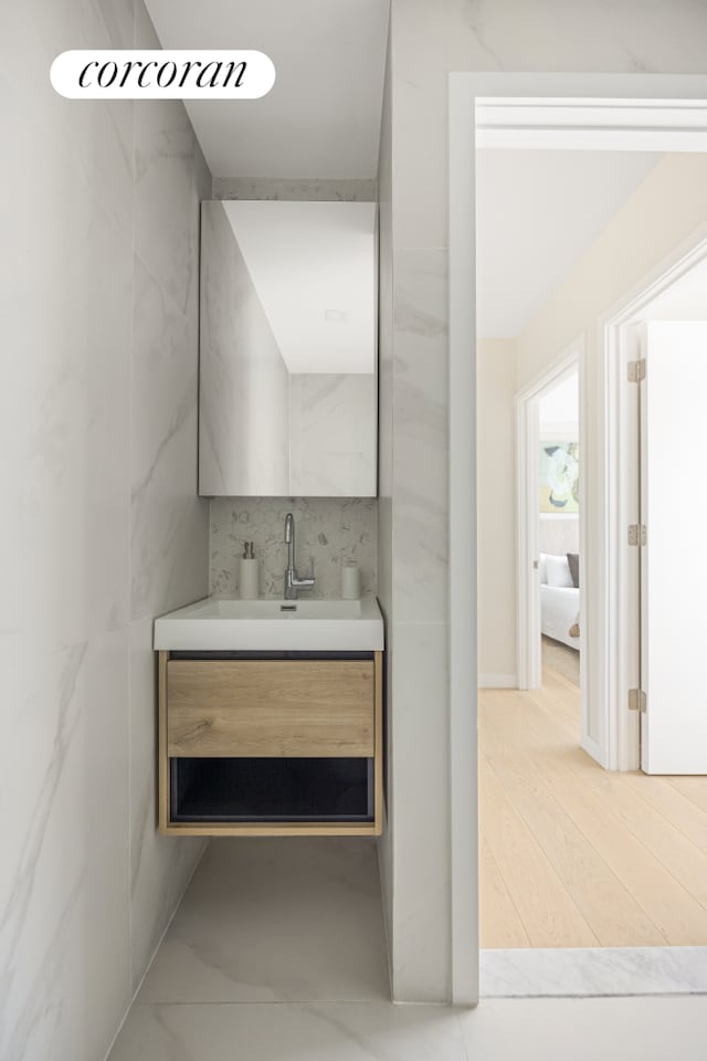 68 Eldert St Unit 3B, New York City, NY 11207 - bathroom featuring vanity, tile walls, and wood finished floors
