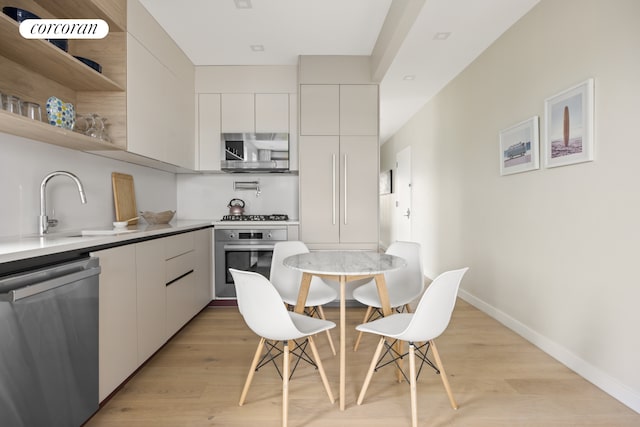 68 Eldert St Unit 3B, New York City, NY 11207 - kitchen featuring appliances with stainless steel finishes, modern cabinets, white cabinets, and light wood-style floors
