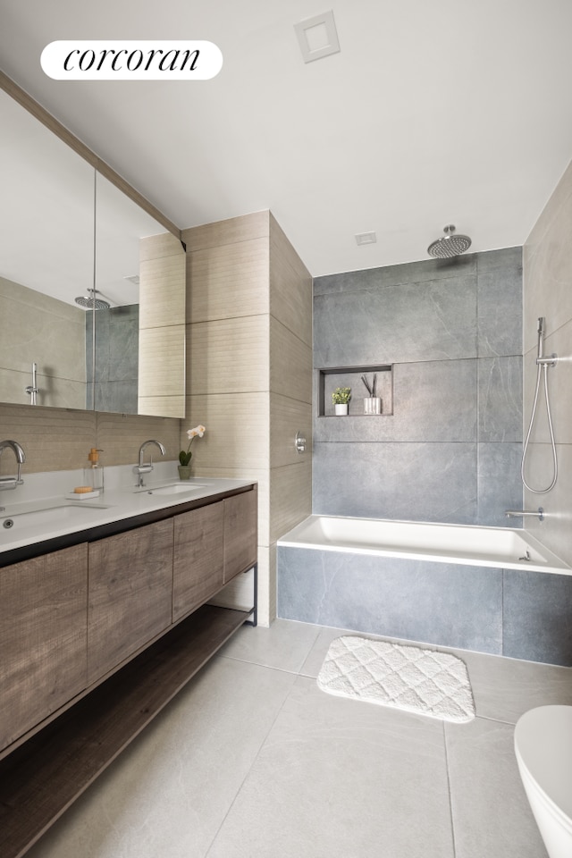 68 Eldert St Unit 3B, New York City, NY 11207 - bathroom featuring tile patterned flooring, double vanity, a combined bath / shower with rainfall shower, and tile walls