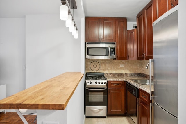 210 E 15th St Unit 4J, New York City, NY 10003 - kitchen featuring stainless steel appliances, a sink, a peninsula, decorative backsplash, and butcher block countertops