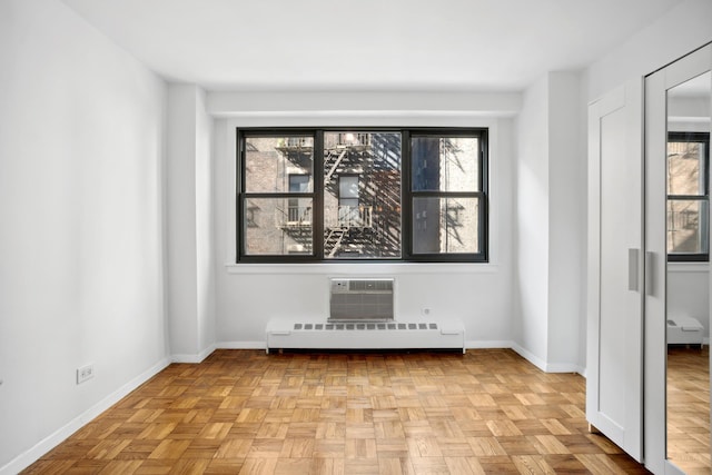 210 E 15th St Unit 4J, New York City, NY 10003 - empty room featuring a baseboard heating unit, a wall mounted air conditioner, baseboards, and plenty of natural light