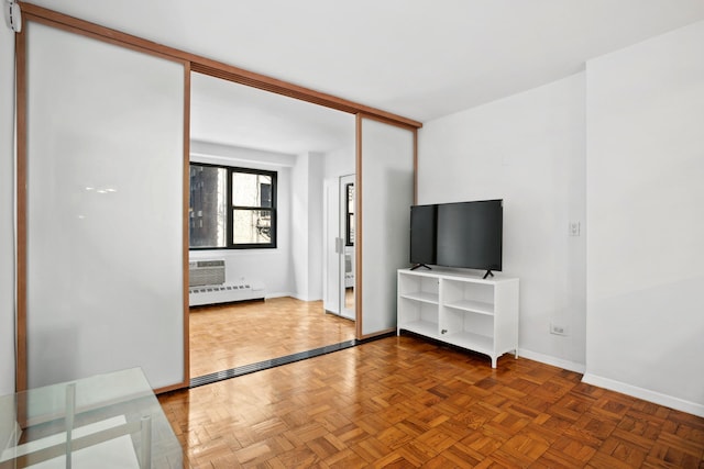 210 E 15th St Unit 4J, New York City, NY 10003 - unfurnished living room featuring a baseboard radiator and baseboards