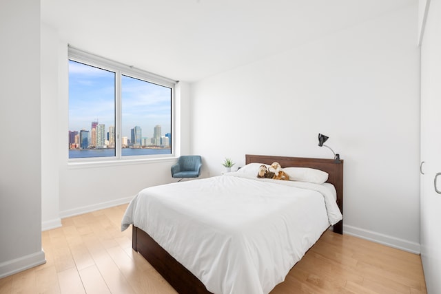 20 River Ter Unit 11L, New York City, NY 10282 - bedroom with wood finished floors, baseboards, and a view of skyline