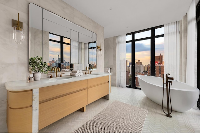 bathroom with french doors, a sink, a city view, and a wall of windows