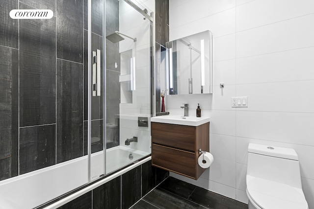 full bathroom featuring vanity, toilet, tiled shower / bath, tile walls, and tile patterned flooring