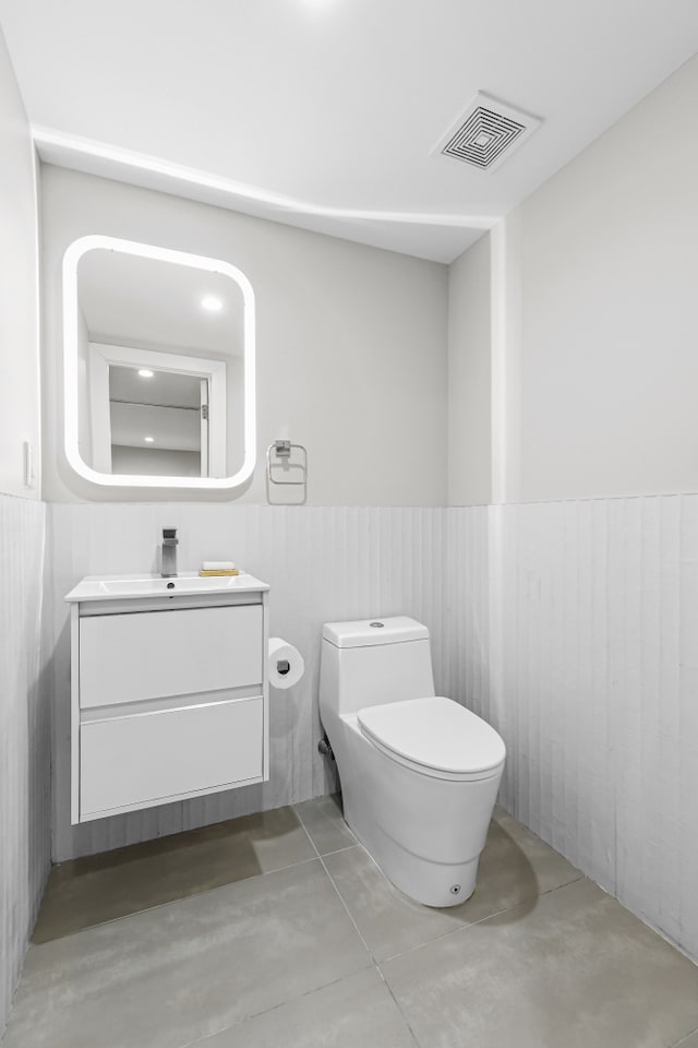 519 Maple St Unit 1B, New York City, NY 11225 - bathroom featuring concrete flooring, vanity, and a wainscoted wall