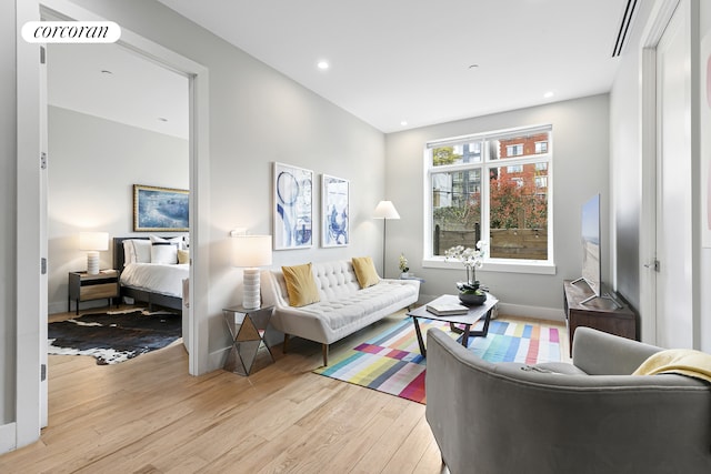 living room with light wood-style floors, recessed lighting, and baseboards