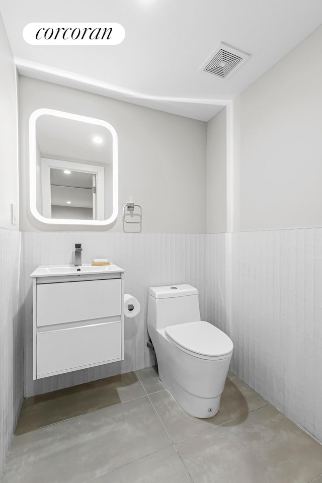519 Maple St Unit 1B, New York City, NY 11225 - bathroom featuring concrete flooring, vanity, and a wainscoted wall