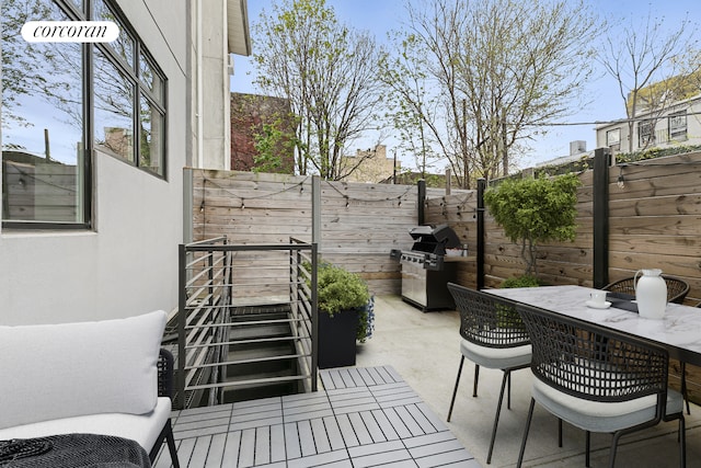 view of patio featuring grilling area, a fenced backyard, and outdoor dining space