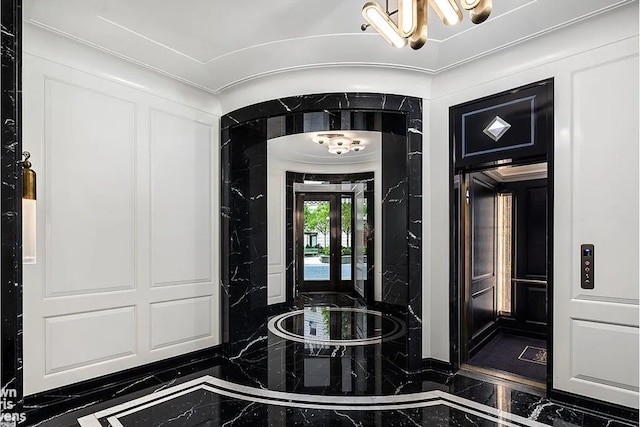 foyer entrance featuring marble finish floor and a notable chandelier