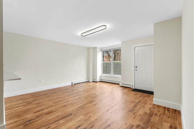 unfurnished room with light wood-style floors, baseboards, a baseboard radiator, and baseboard heating