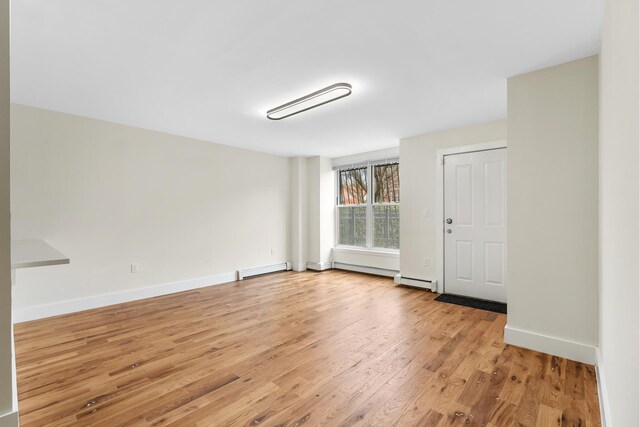 2108 Dean St, New York City, NY 11233 - spare room featuring light wood finished floors, baseboard heating, and baseboards