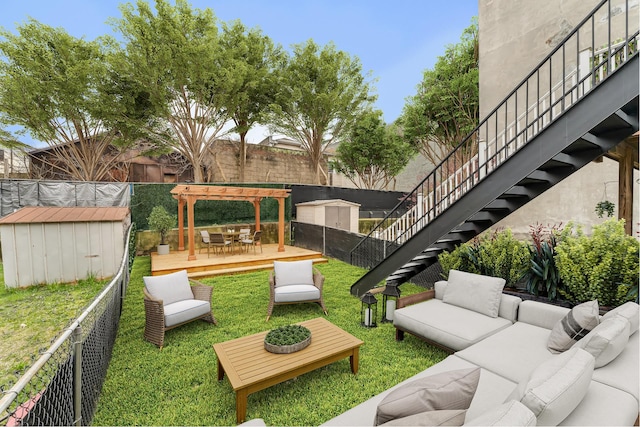 view of yard featuring a wooden deck, a shed, outdoor lounge area, a fenced backyard, and an outdoor structure