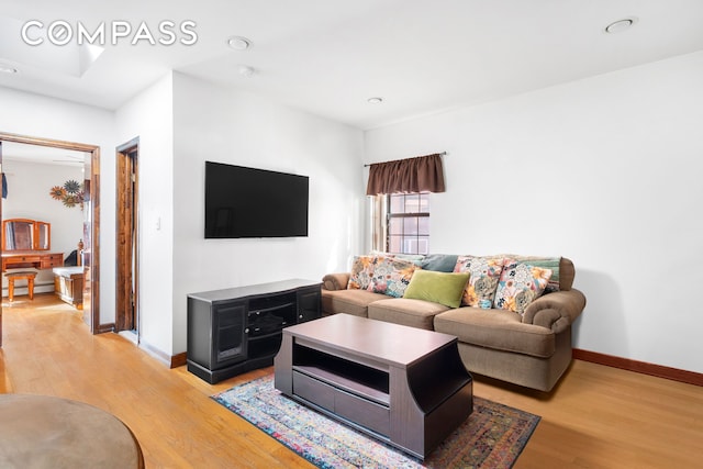 living area featuring recessed lighting, baseboards, baseboard heating, and light wood finished floors