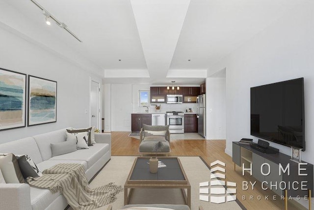 302 2nd St Unit 12H, New York City, NY 11215 - living area featuring light wood-style flooring, a raised ceiling, and rail lighting